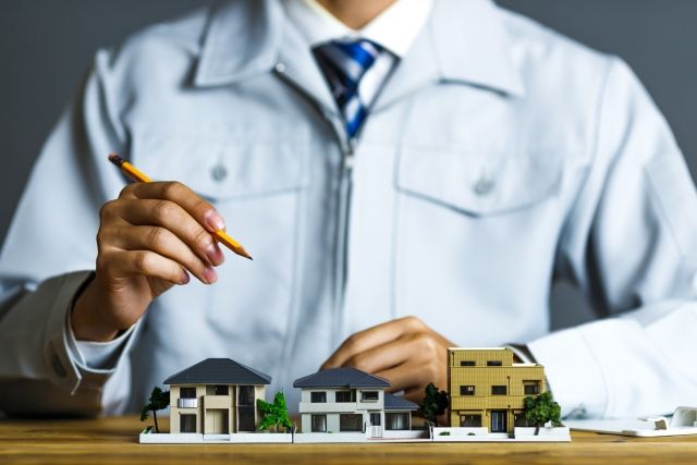 家の模型と鉛筆を持つ建築士